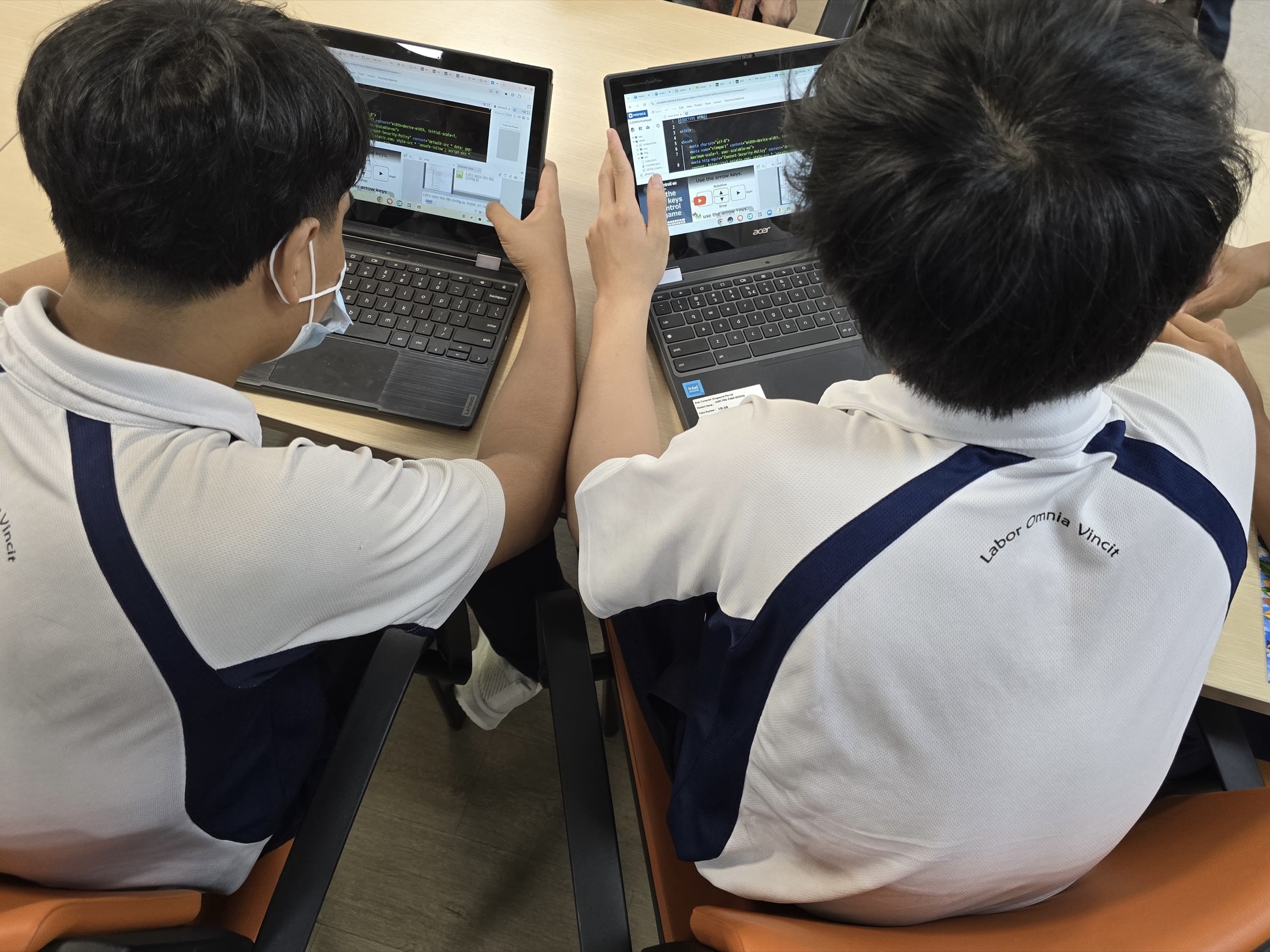 Students working through GAKU Programming with code and Puyo Puyo on screen